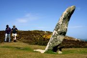 Walkers approach the Old Man of Gugh, a standing stone on the little island of Gugh.