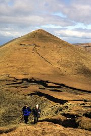 Walkers climb onto Galtymore, with Galtybeg seen beyond, in the heart of Ireland.